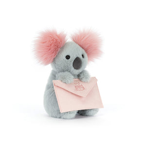 Jellycat grey plush koala toy with pink ears holding a pink envelope on a white background
