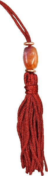 Red tassel with a wooden bead on a white background