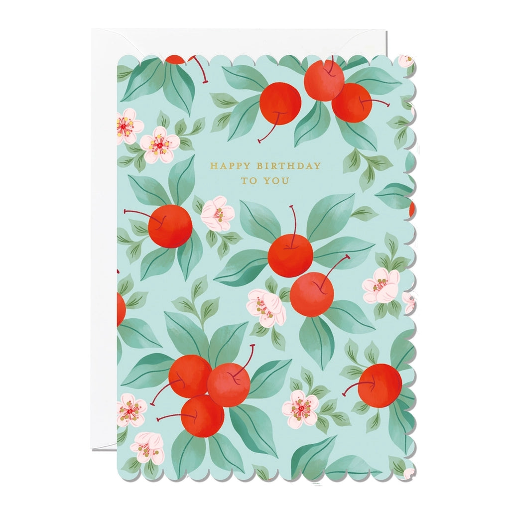 Birthday card with a scalloped edge and a cherry and floral design on a light blue background. The card contains the text 'Happy Birthday To You'.