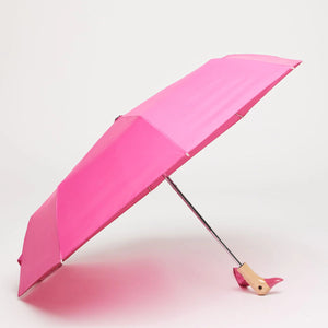 Opened pink umbrella with a wooden handle and duck shaped handle on a white background.