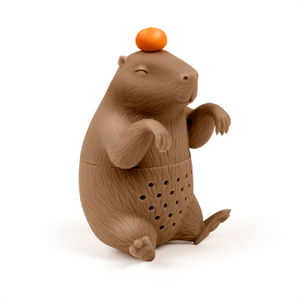 Image of a brown capybara-shaped tea infuser with an orange balancing on it's head on a white background.