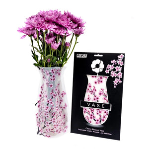 Expandable vase with a cherry blossom design filled with a bouquet of purple flowers. The vase is placed beside it's packaging with Modgy branding.