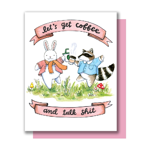 A greeting card with an illustration of a rabbit and a raccoon holding drinks in a grassy field, with text above them reading 'let's get coffee and talk shit'. 
