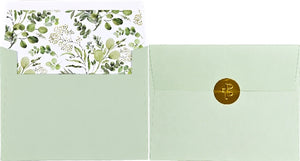 Two light green envelopes placed side by side; one is open showing a white and green eucalyptus themed interior print, the other is closed and sealed with a circular gold sticker. 
