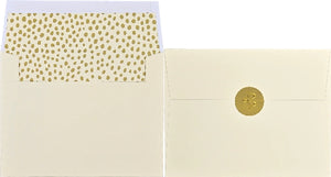 Two cream coloured envelopes placed side by side. One is open and shows a polka dot inner lining. The other is closed and sealed with a gold sticker. 