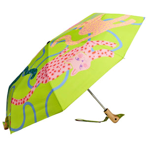 Side view of an opened green umbrella with an abstract cat print and a wooden duck head shaped handle on a white background. 