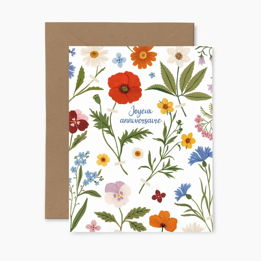 Greeting card featuring a colourful floral design with the text 'Joyeux anniversaire' and a brown envelope.