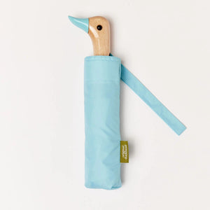 Blue umbrella with a wooden duck head shaped handle on a white background. 