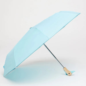 Opened blue umbrella with a wooden duck head shaped handle on a white background. 