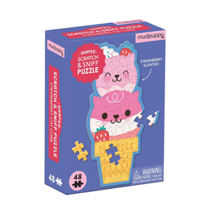 Mudpuppy strawberry cat cone puzzle packaging on a white background. The packaging features an image of the finished puzzle which is in the style of a cone with two scoops of ice-cream in the shape of two smiling cat heads, two strawberries and some cream with sprinkles on top.