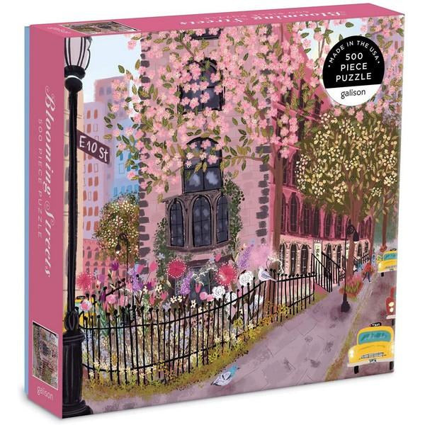 A puzzle box featuring an illustrated pink floral NYC street scene on the cover.