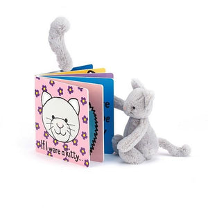Jellycat board book titled 'If I were a kitty...' featuring an image of a grey smiling cat face on a pink background with purple and yellow flowers, placed beside a grey cat plush toy