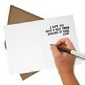 Image of a hand writing a message inside a greeting card on a white background with a brown envelope.